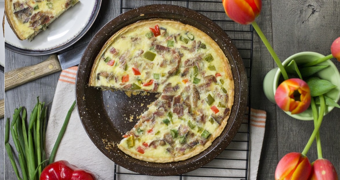 quiche in pan with one slice taken out